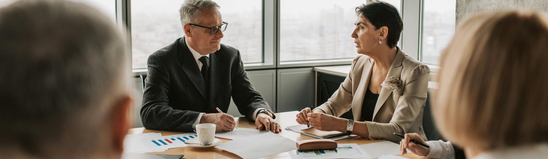 Business professionals engaged in a strategic meeting in a modern office setting with natural light.